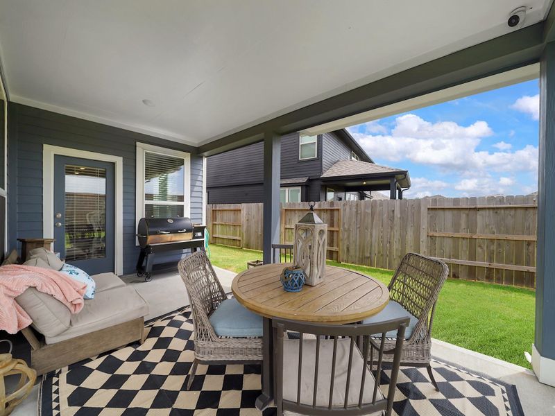 The covered patio offers a comfortable setting to enjoy the outdoors year-round, with plenty of room for seating and entertaining.