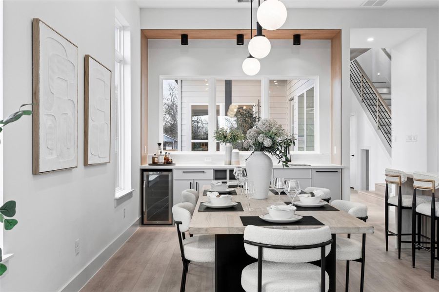 A tailored bar niche anchors the room with symmetry and contrast, seamlessly integrated between dining and kitchen. The composition feels intentional, balanced, and effortlessly refined.