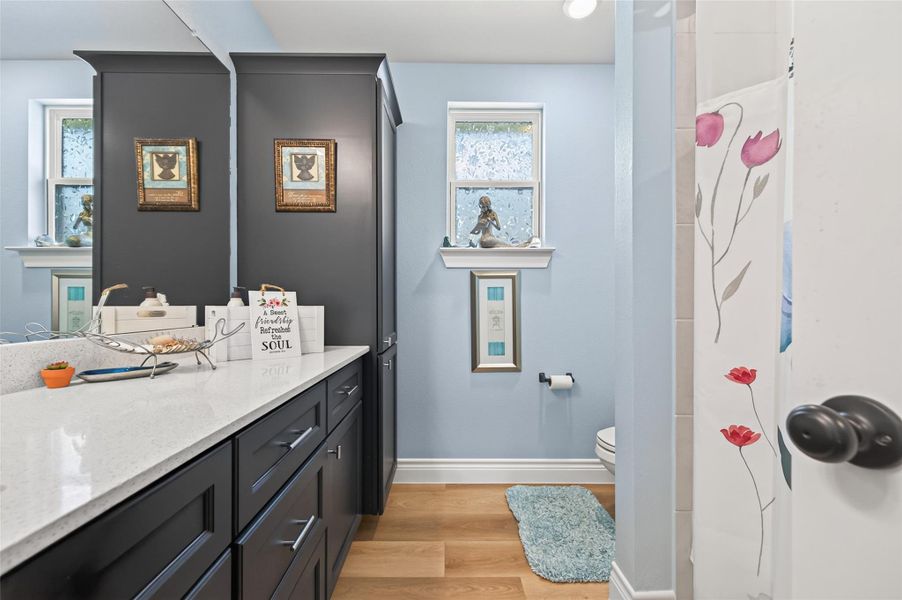 This beautifully appointed secondary bathroom features an expansive custom vanity with ample cabinet space, complemented by floor-to-ceiling linen shelving that provides maximum storage convenience and a clean, organized aesthetic for all your daily essentials. This beautifully appointed secondary bathroom features an expansive custom vanity with ample cabinet space, complemented by floor-to-ceiling linen shelving that provides maximum storage convenience and a clean, organized aesthetic for all your daily essentials.