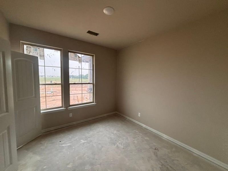 Room featuring a neutral wall color, two large windows, and a ceiling light fixture