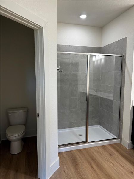 Full bath with wood finished floors and a stall shower Full bath with wood finished floors and a stall shower