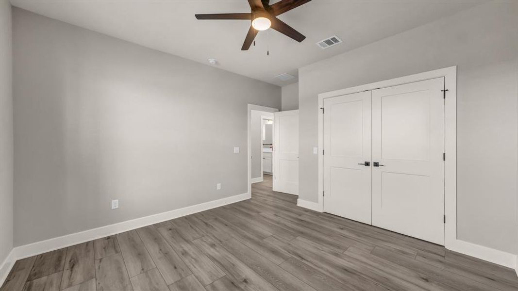 Unfurnished bedroom with wood finished floors, a closet, and a ceiling fan Unfurnished bedroom with wood finished floors, a closet, and a ceiling fan