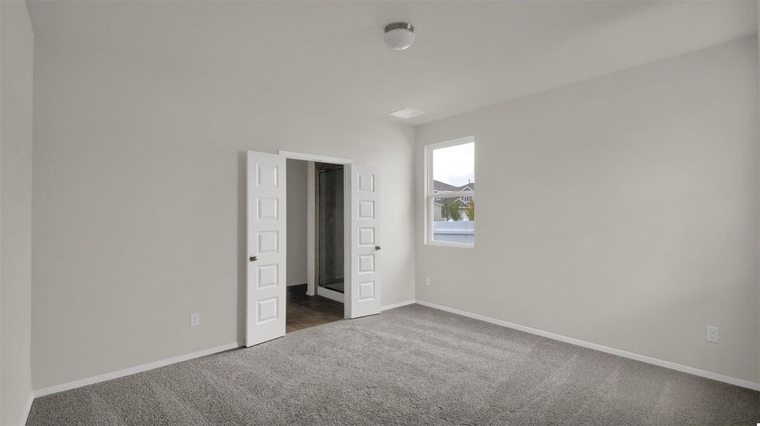 Unfurnished bedroom with carpet flooring and baseboards