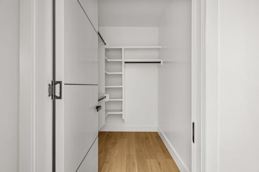 Functional closet featuring built-in shelving and a sturdy hanging rod for organized storage. Functional closet featuring built-in shelving and a sturdy hanging rod for organized storage.