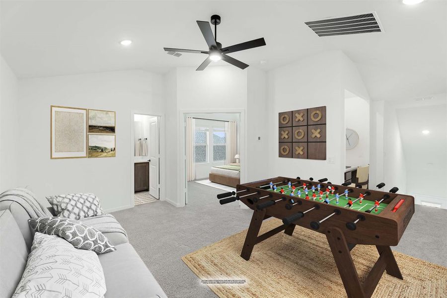 Game room with foosball table, gray sofa, carpet flooring, and vaulted ceiling with ceiling fan Game room with foosball table, gray sofa, carpet flooring, and vaulted ceiling with ceiling fan