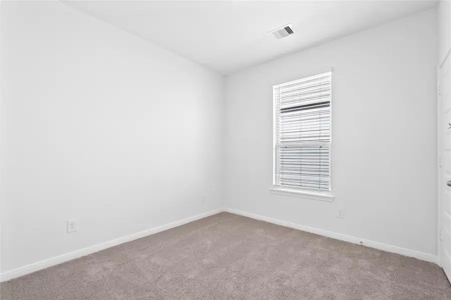 This secondary bedroom offers comfort and style with plush carpeting, neutral paint tones, recessed lighting, a large window with blinds, and a generously sized closet This secondary bedroom offers comfort and style with plush carpeting, neutral paint tones, recessed lighting, a large window with blinds, and a generously sized closet