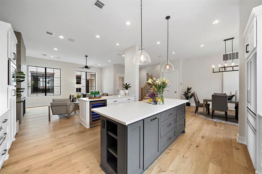 The contrasting center island has cookbook shelves, concealed trash bins, and drawers for cookware.