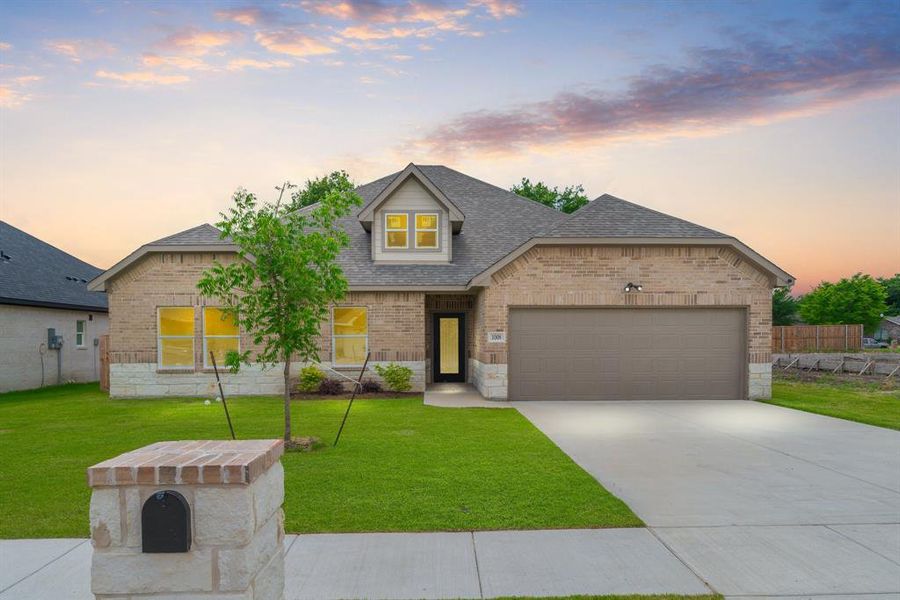 View of front of property with a garage and a yard