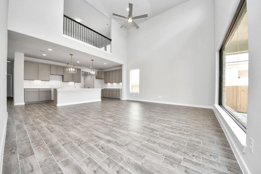 Family room flooded with natural light through the expansive windows.  The premium tile flooring adds a touch of luxury to the space, creating the perfect setting for relaxing moments and cherished gatherings with loved ones