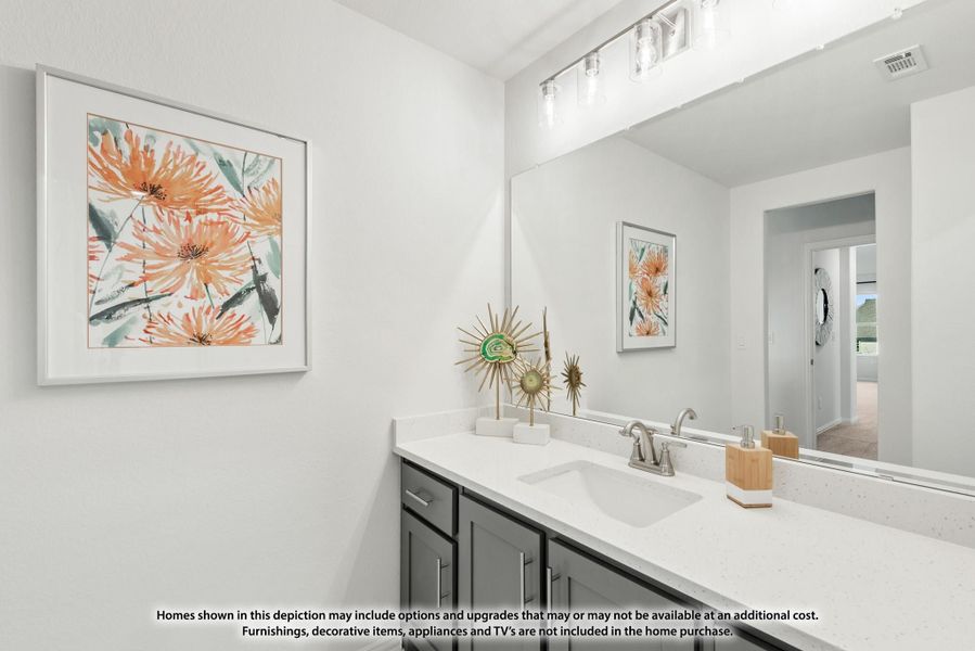 Bathroom vanity with dark cabinets, white countertop, single sink, large mirror, and floral wall art Bathroom vanity with dark cabinets, white countertop, single sink, large mirror, and floral wall art