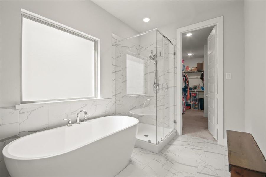 Soaking up and oversized shower allow for relaxation after a long day. Primary closet circles to the laundry room for an added convenience.