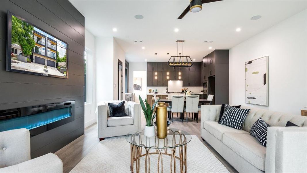 Living room with ceiling fan and light hardwood / wood-style floors