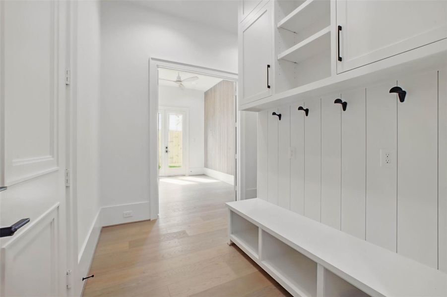 Sample of builder's previous construction. This home will have a similar mud area.  This new construction will have a similar layout as pictured here: door on the left leads to the garage, room in the back is the flex room and hallway leads to the downstairs guest suite. Buyer still has time to select finishes.