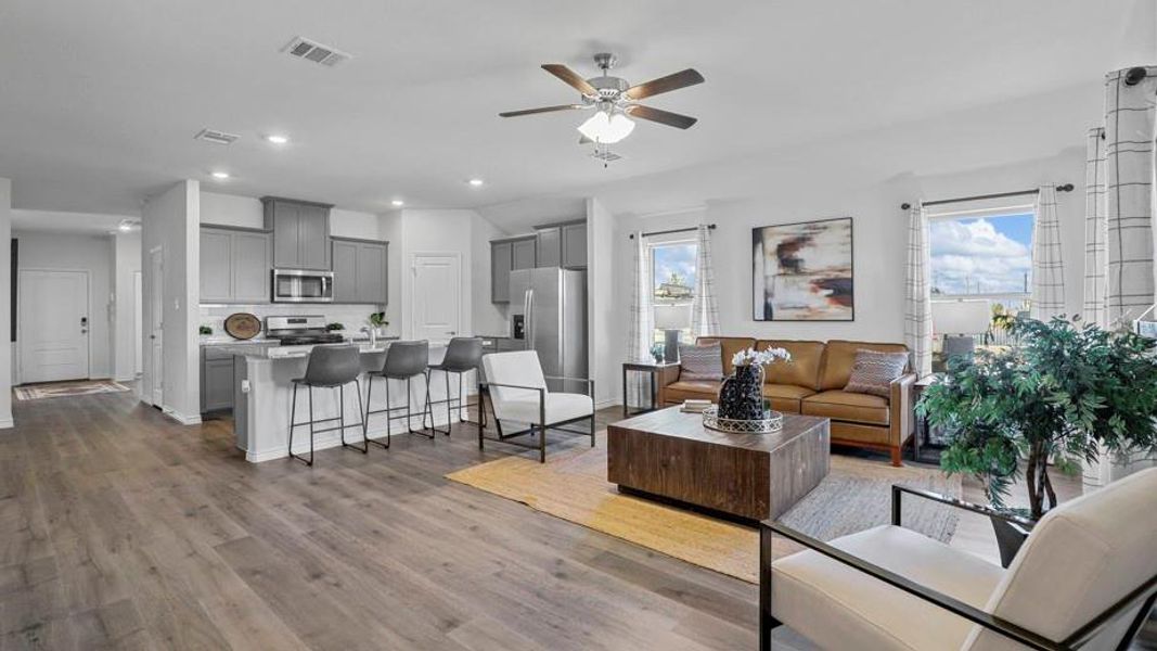 Living area featuring dark wood finished floors, ceiling fan, and recessed lighting