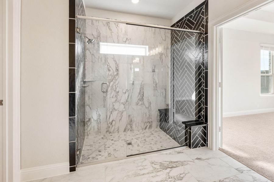 Walk-in shower with glass doors, white marble tile walls, and black herringbone accent tiles with built-in bench seat Walk-in shower with glass doors, white marble tile walls, and black herringbone accent tiles with built-in bench seat