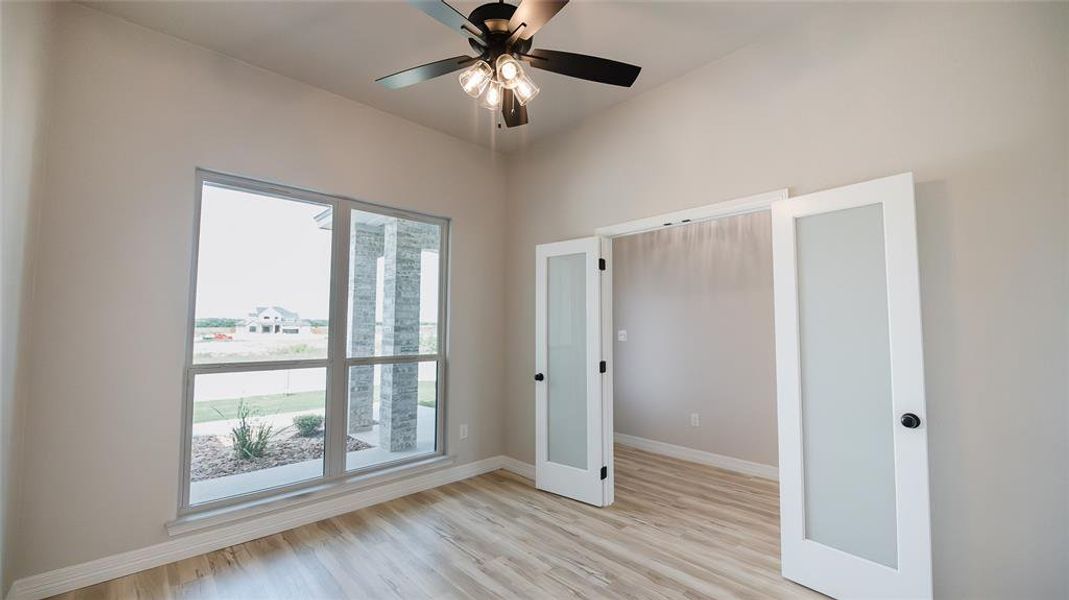 Unfurnished bedroom with light wood-style floors and a ceiling fan Unfurnished bedroom with light wood-style floors and a ceiling fan