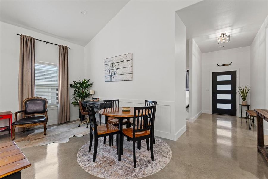 Dining area with finished concrete flooring and lofted ceiling