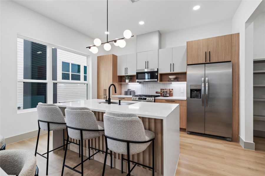 This kitchen tells a story of modern ease—clean lines, natural wood tones, and light-filled windows create a calming atmosphere you’ll love coming home to.
