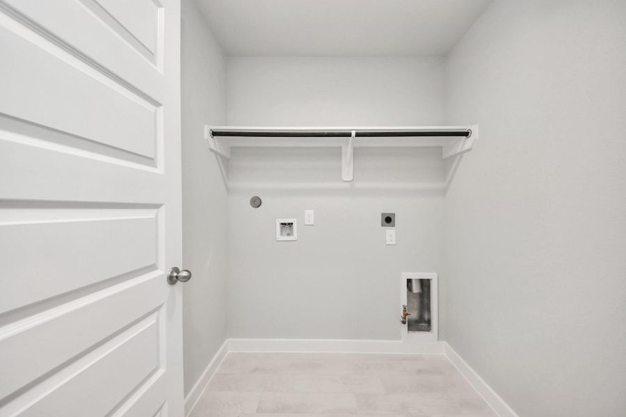 A perfect blend of functionality and comfort. Capture the essence of easy living with a first-floor laundry room, thoughtfully equipped with shelving for effortless organization. Both electric and gas connections available. Sample photo of completed home with similar floor plan. Actual colors and selections may vary. A perfect blend of functionality and comfort. Capture the essence of easy living with a first-floor laundry room, thoughtfully equipped with shelving for effortless organization. Both electric and gas connections available. Sample photo of completed home with similar floor plan. Actual colors and selections may vary.