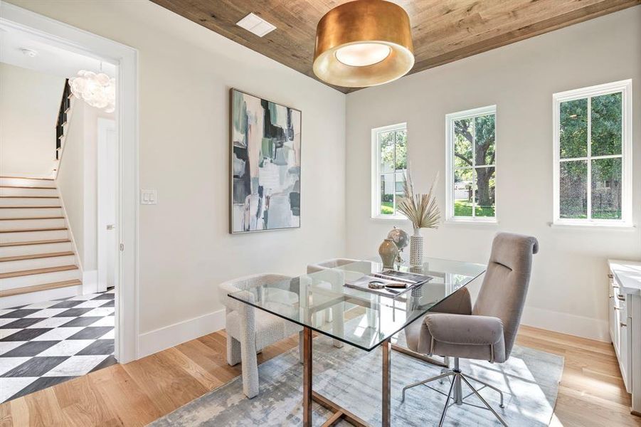 Dining area with light hardwood / wood-style floors, wood ceiling, and a wealth of natural light