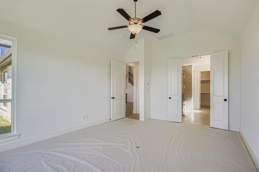 Unfurnished bedroom with lofted ceiling, ceiling fan, and carpet floors Unfurnished bedroom with lofted ceiling, ceiling fan, and carpet floors