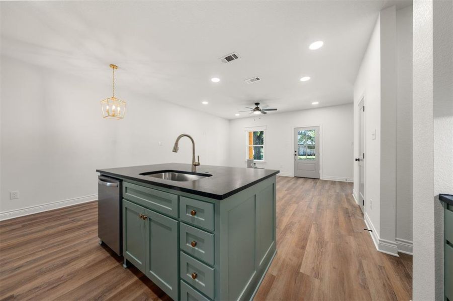 Kitchen with green cabinets, a kitchen island with sink, hanging light fixtures, dark wood finished floors, and recessed lighting Kitchen with green cabinets, a kitchen island with sink, hanging light fixtures, dark wood finished floors, and recessed lighting