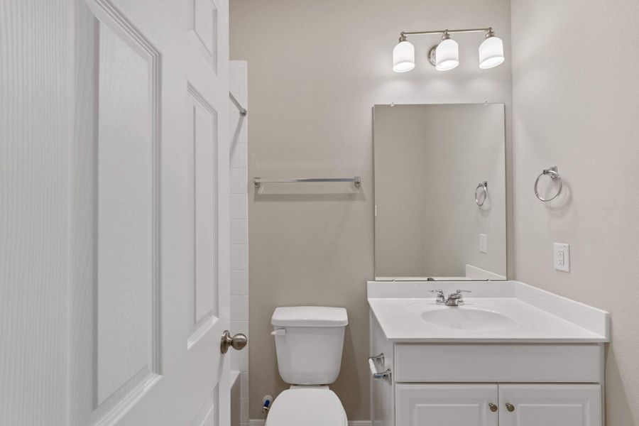 The private  bath features tile flooring, white cabinetry and light countertops and a shower/tub combo. Perfect for accommodating any visiting family and friends.