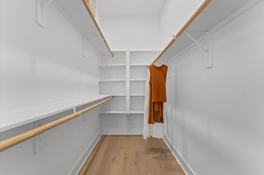 This well-proportioned primary closet offers a practical blend of space and organization, ideal for everyday use. With ample room for hanging garments and shelving for folded items or accessories, it balances functionality with comfort. The layout allows for easy access and visibility, making it simple to keep clothing and essentials neatly arranged. Whether customized with built-ins or left open for flexible storage, the closet serves as a tidy extension of the primary suite.