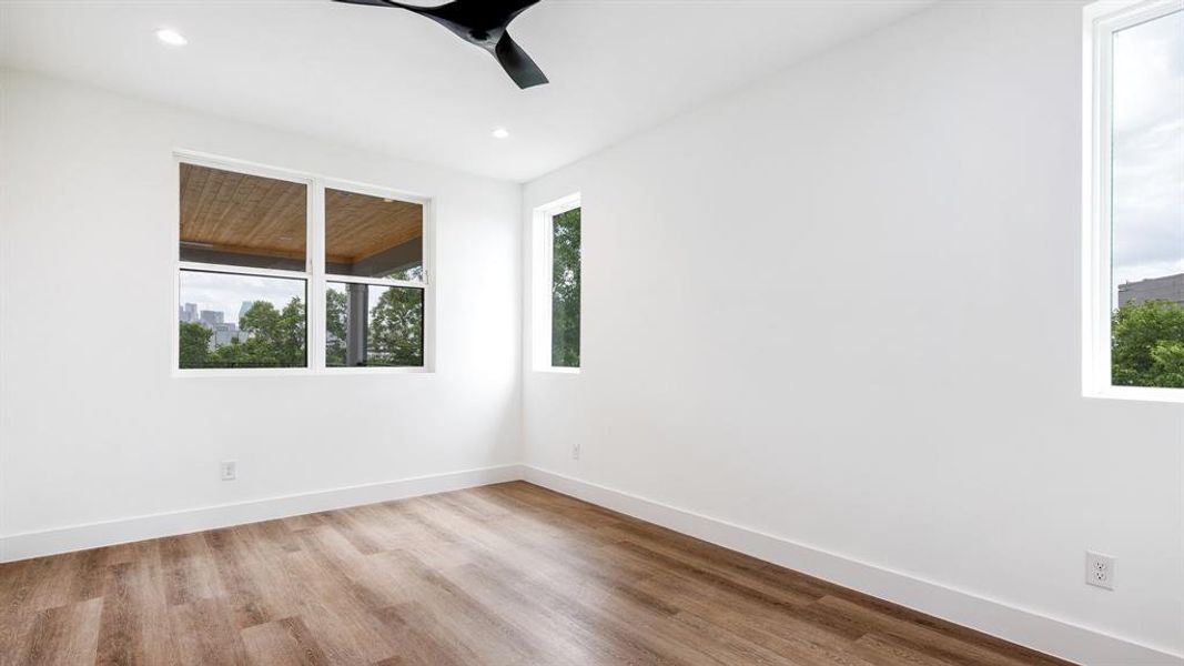 Empty room with ceiling fan and light wood-type flooring