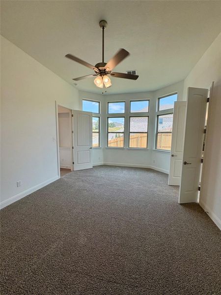 Unfurnished bedroom featuring carpet floors and a ceiling fan Unfurnished bedroom featuring carpet floors and a ceiling fan