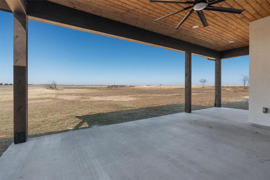 View of patio with ceiling fan and a rural view