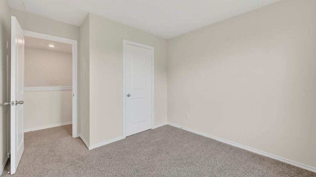 Carpeted room featuring light gray walls, white baseboards, and white interior doors