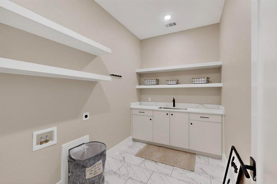 Laundry room with washer hookup, cabinet space, light marble finish flooring, and electric dryer hookup