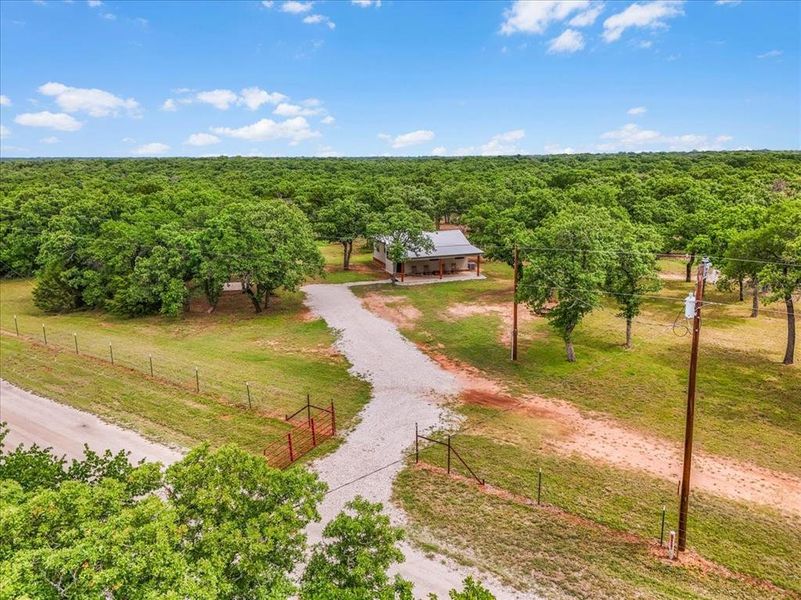 Expansive rural property featuring a gravel driveway and a fenced perimeter