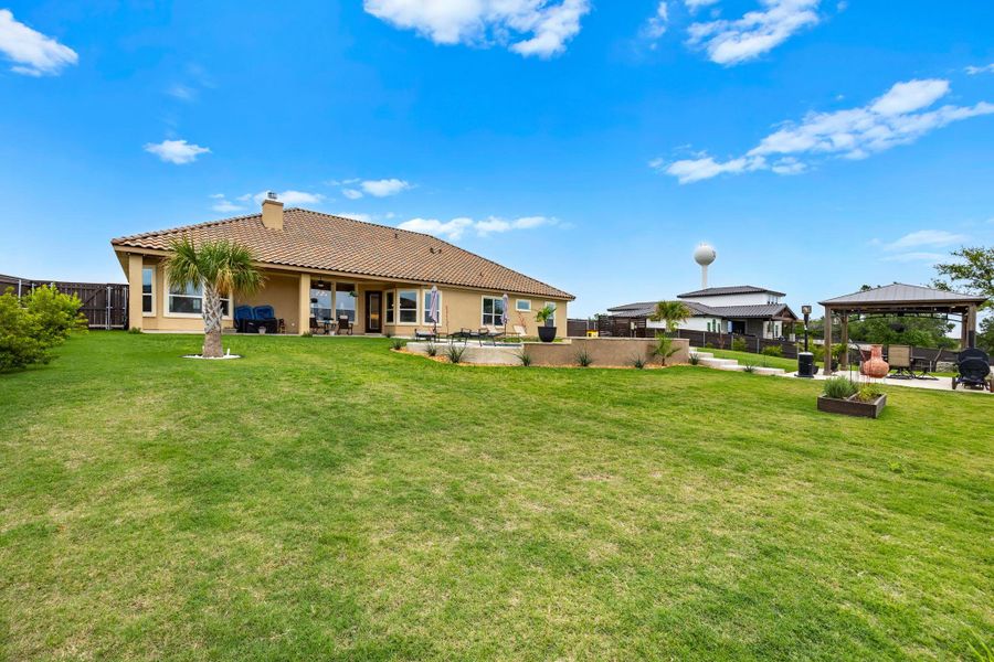 An inviting backyard oasis features a patio, pergola, and lush green lawn, perfect for relaxation and entertaining. An inviting backyard oasis features a patio, pergola, and lush green lawn, perfect for relaxation and entertaining.