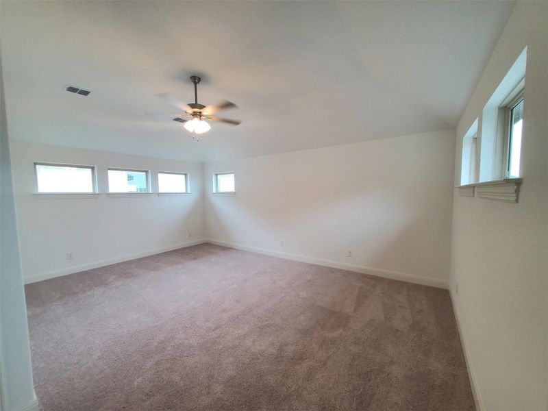 Unfurnished room with baseboards, visible vents, a ceiling fan, and light colored carpet Unfurnished room with baseboards, visible vents, a ceiling fan, and light colored carpet