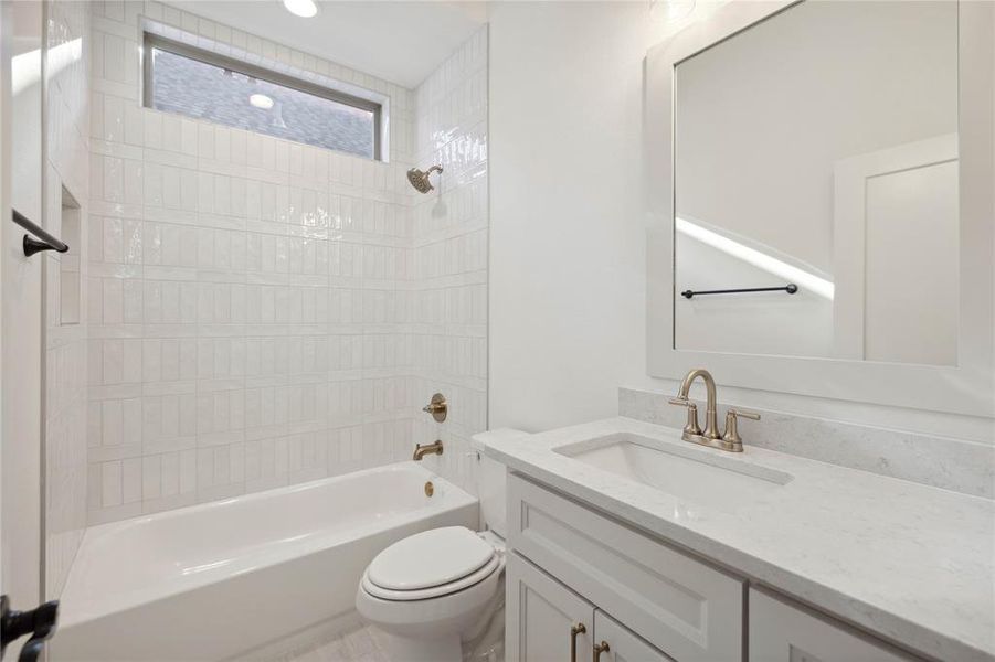 Full bathroom with toilet, vanity, and tiled shower / bath