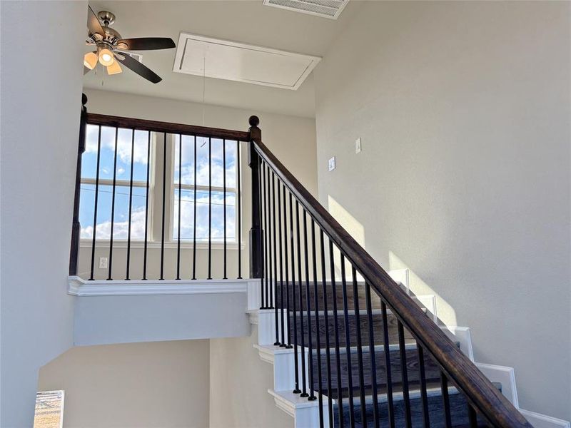 Stairway with attic access and a ceiling fan