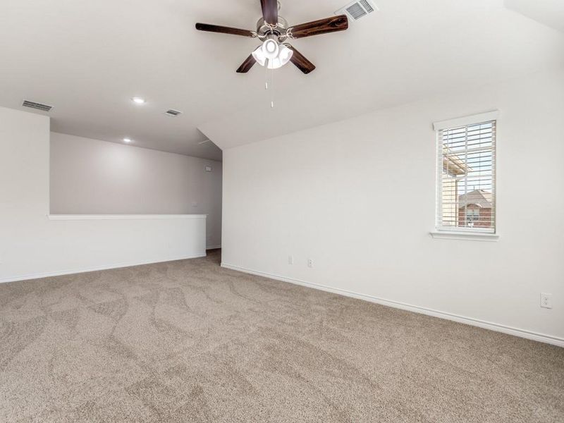 room with light colored carpet and a ceiling fan