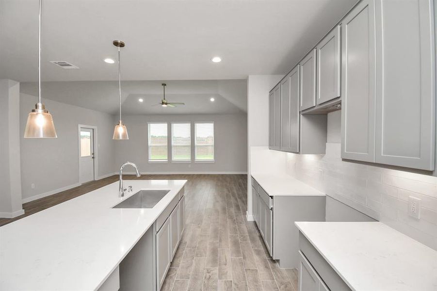 Discover another perspective of this stunning kitchen, generously appointed with an abundance of counter space. Sample photo of completed home with similar floor plan. Actual colors and selections may vary.