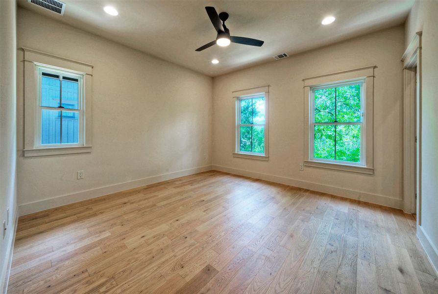 Hardwood floors and generous window light create a bright and airy private space.