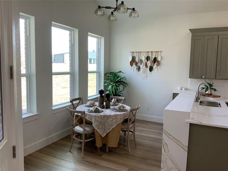 Dining room with light wood finished floors and suspended lighting Dining room with light wood finished floors and suspended lighting