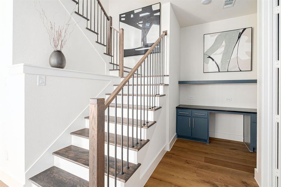 Stairway with wood finished floors and built in study area