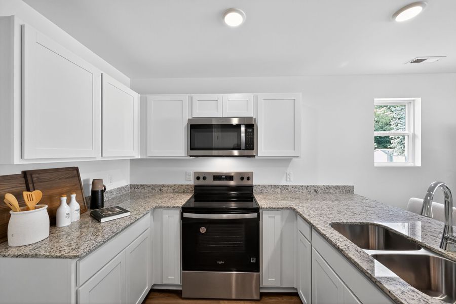 A kitchen with white cabinets.
