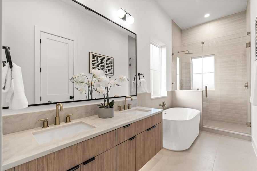 Primary bathroom with floating vanity, freestanding soaking tub, and custom tiled shower. Primary bathroom with floating vanity, freestanding soaking tub, and custom tiled shower.