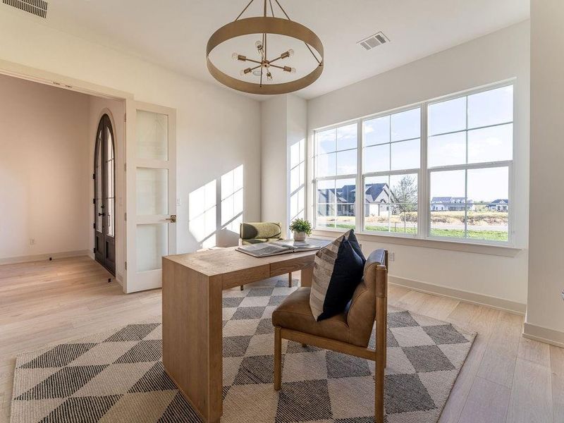 Office area featuring light wood-type flooring and a chandelier