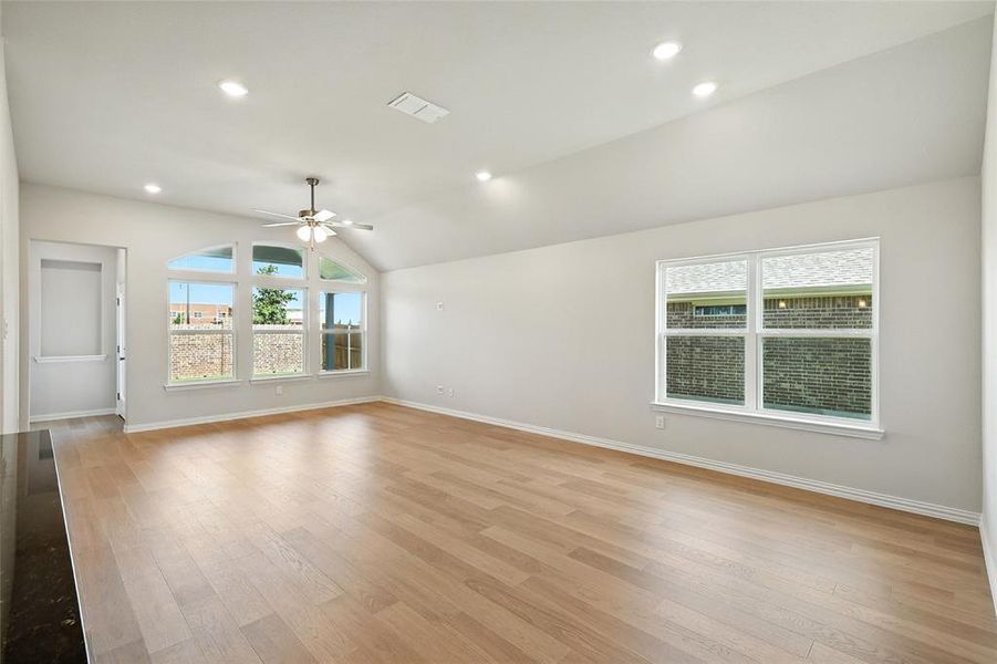Unfurnished living room featuring a ceiling fan, light wood-style flooring, vaulted ceiling, and recessed lighting Unfurnished living room featuring a ceiling fan, light wood-style flooring, vaulted ceiling, and recessed lighting