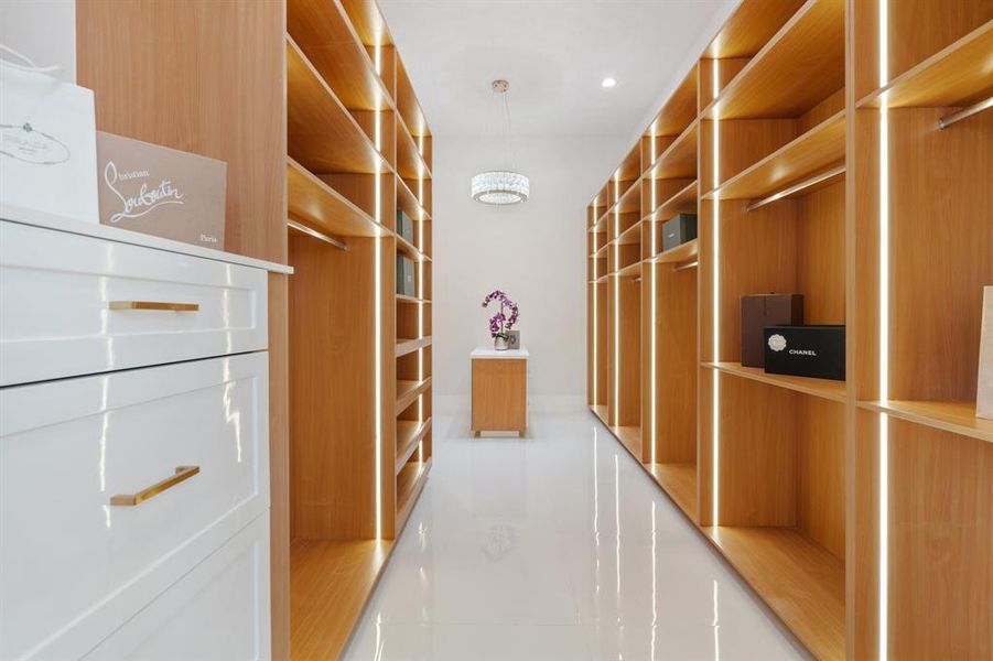 Step into a custom closet adorned with LED lighting and designer fixtures, creating a glamorous and functional space for all your wardrobe needs.