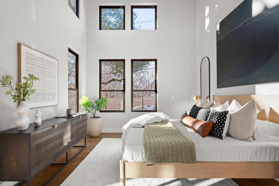 Bedroom featuring wood finished floors and a towering ceiling