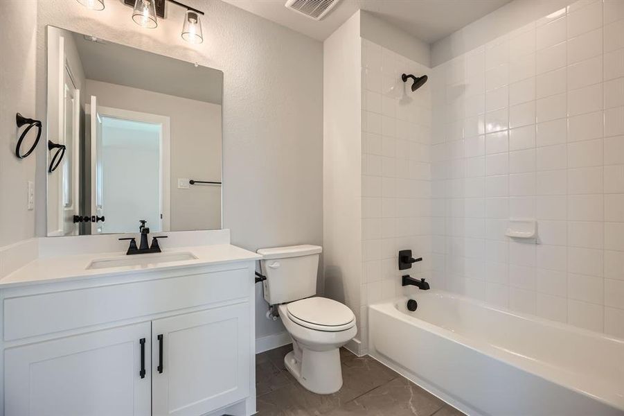 Bathroom with toilet, vanity, and tub / shower combination Bathroom with toilet, vanity, and tub / shower combination